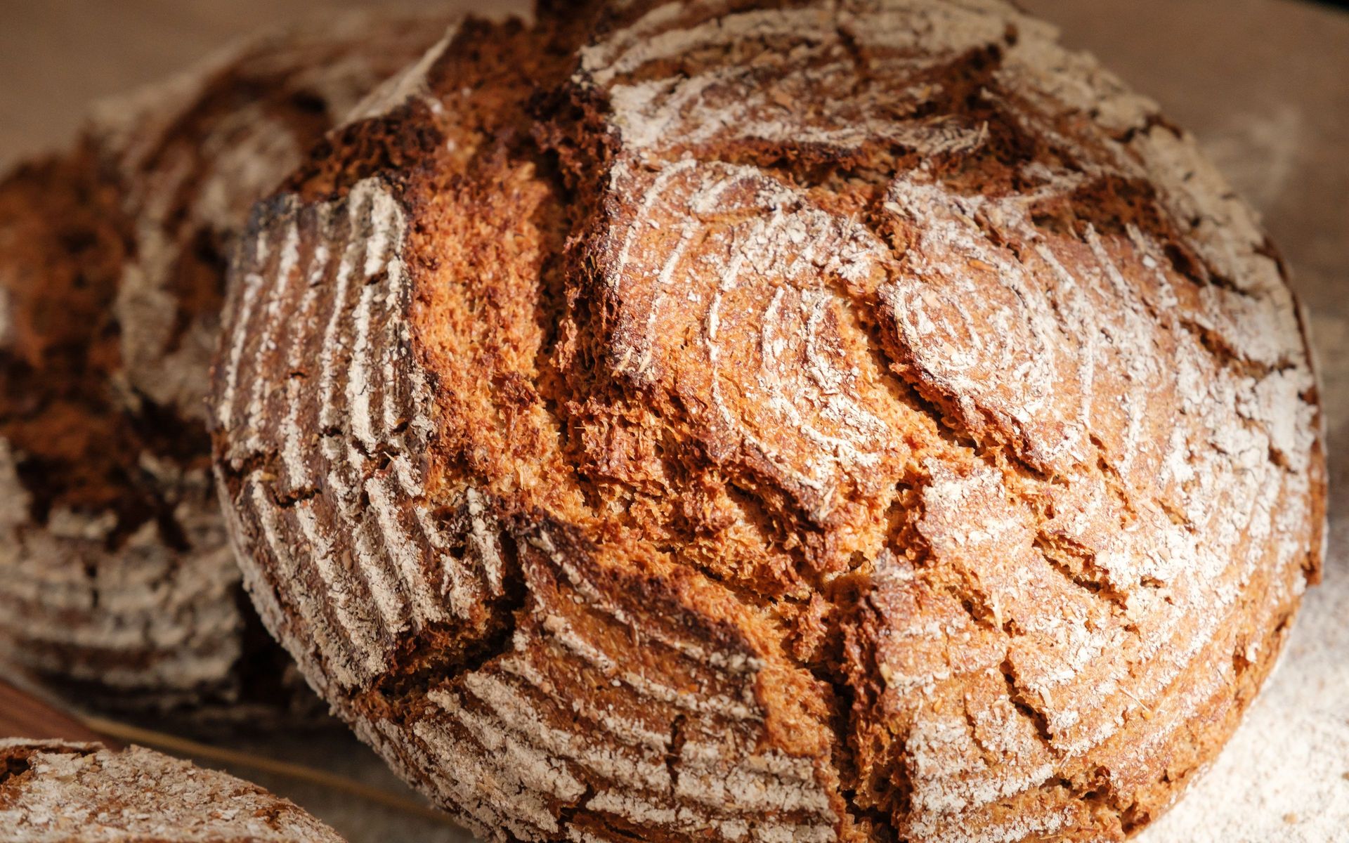 Rustic wholegrain sourdough loaf with crisp crust, banneton pattern and flour dusting